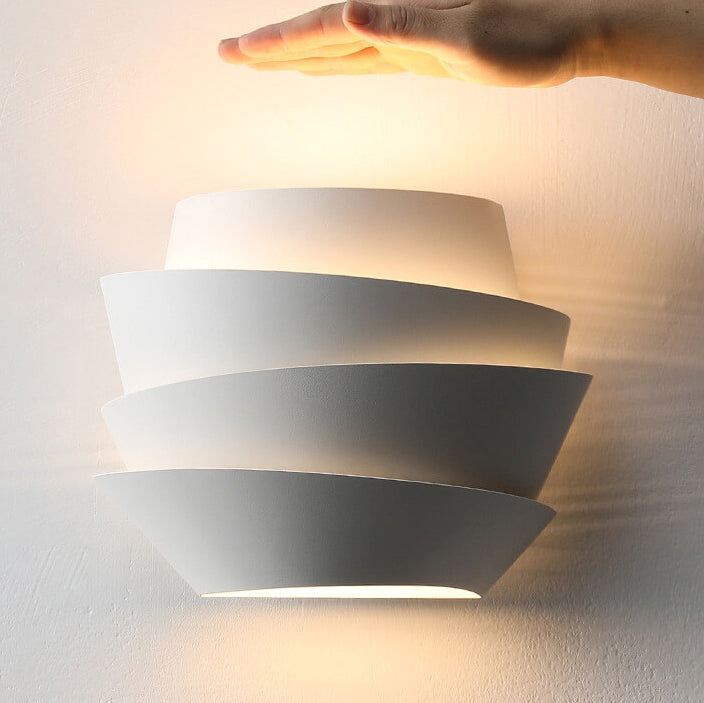 Modern white iron dual-light wall lamp mounted on a wall with warm light glowing upward.