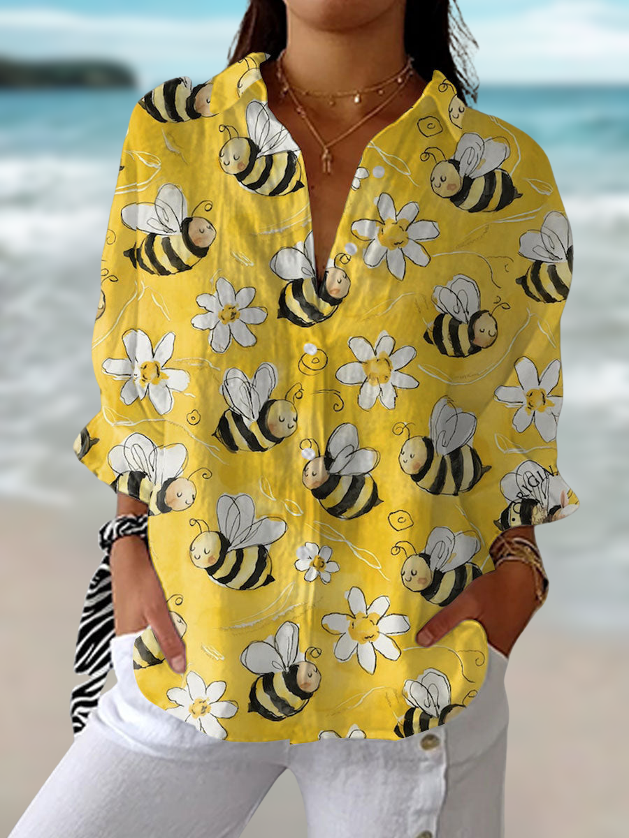 Woman wearing a yellow bee and floral print blouse by the beach