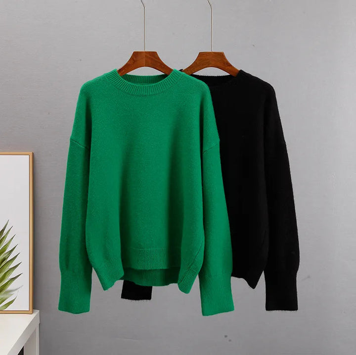 Folded stack of cozy winter sweaters including green and blue knit jumpers
