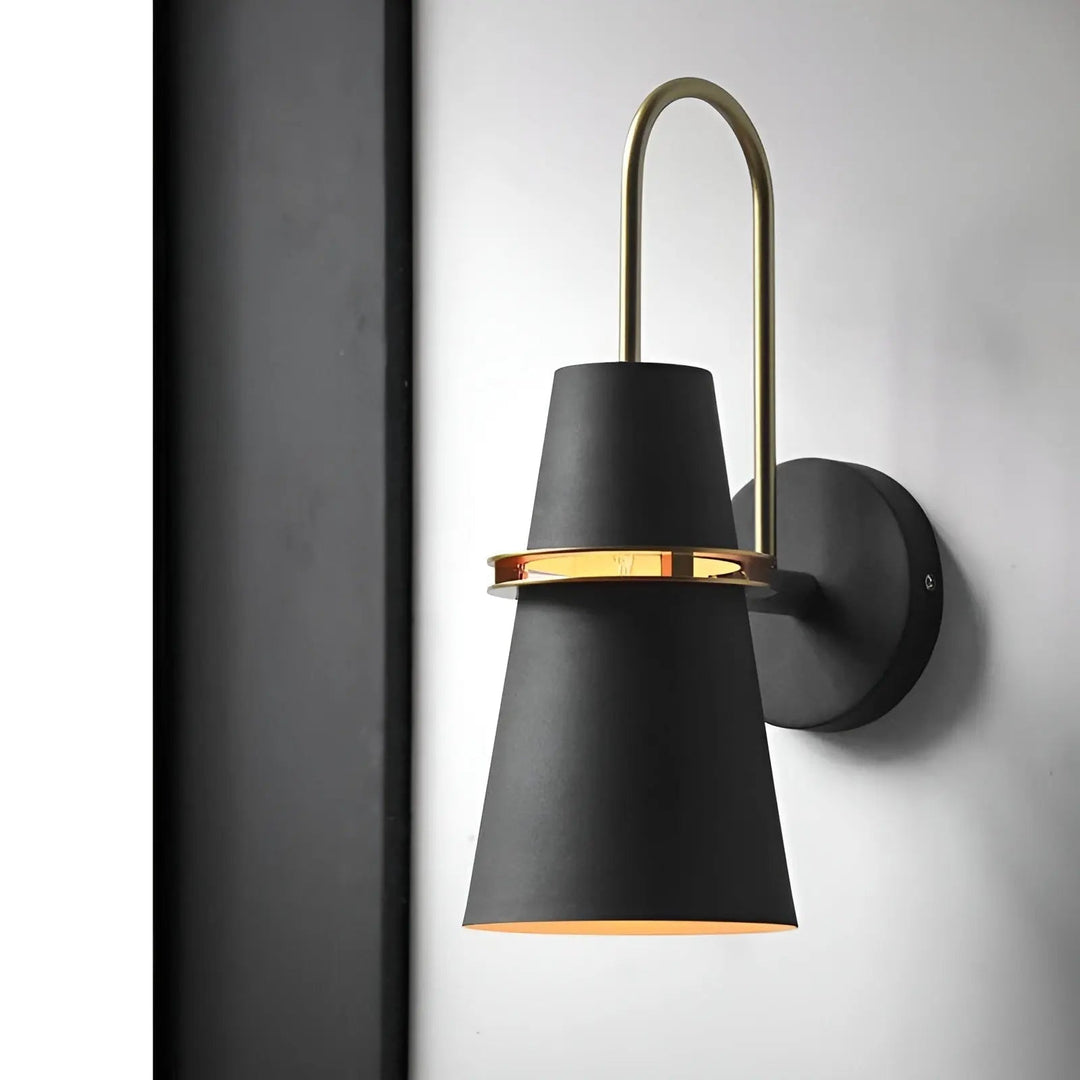 Black modern LED wall lamp mounted on a wall with gold accent hardware