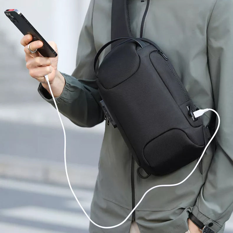 Person wearing black anti-theft waterproof crossbody bag while holding phone with connected cable