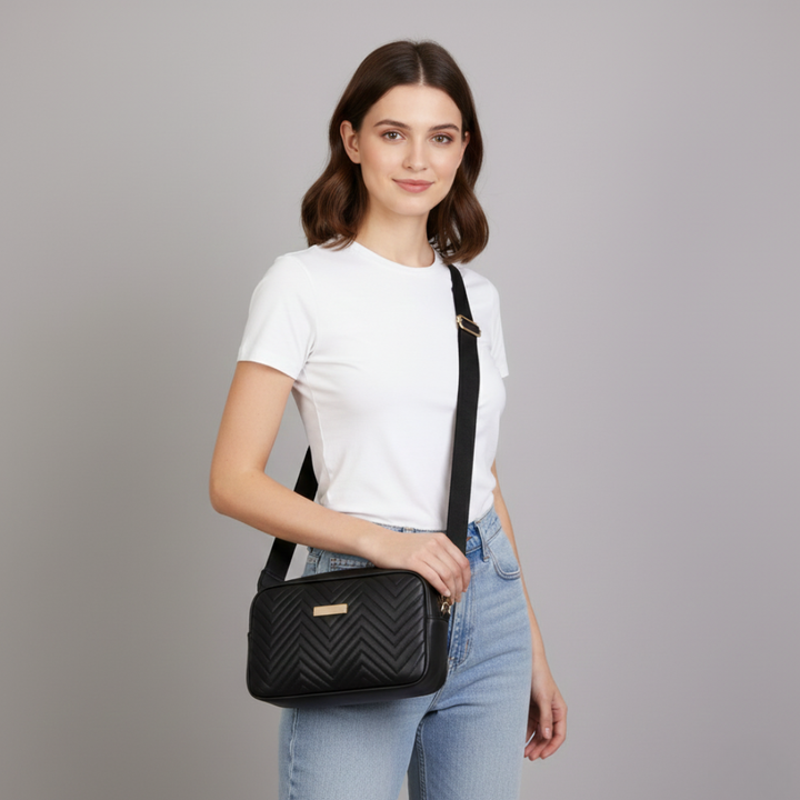 Model wearing a black quilted mini crossbody bag with a white t-shirt and jeans