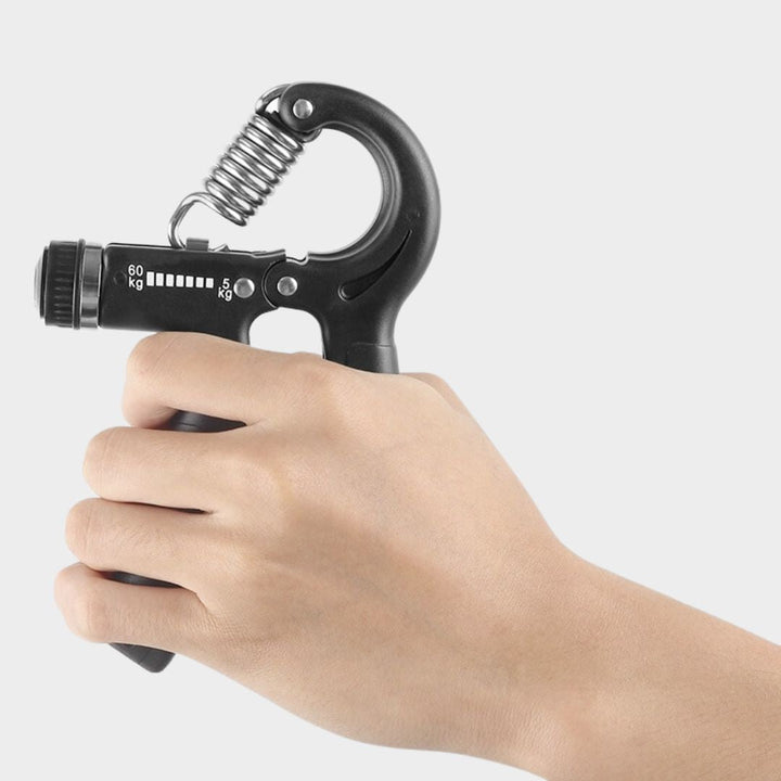 Close-up of a black adjustable resistance hand gripper held in hand