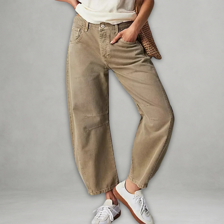 Woman wearing beige chic baggy jeans with a white top and sneakers
