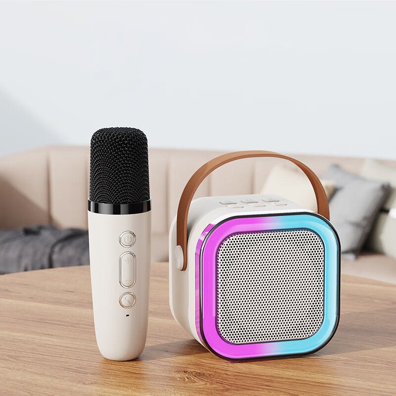 White wireless karaoke speaker paired with a single microphone on a wooden table