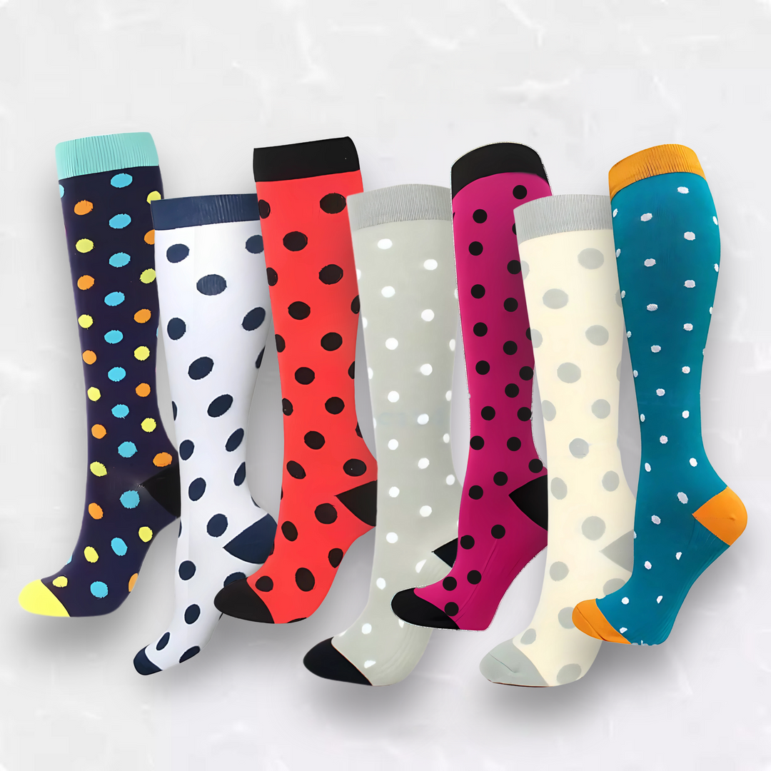 Collection of colorful patterned compression socks laid out on a white background