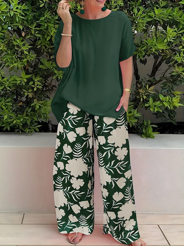 Woman wearing a green relaxed two-piece top and floral wide-leg trousers