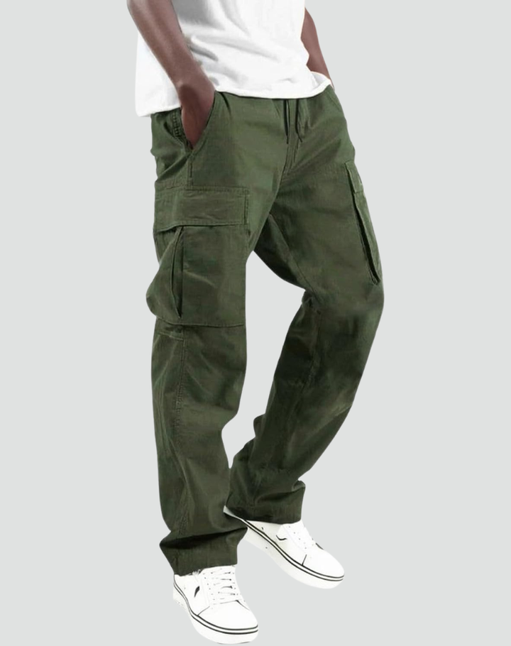 Man wearing olive green cargo trousers with multiple pockets paired with white sneakers