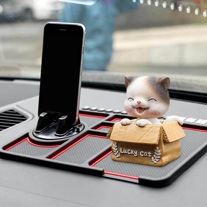Black car dashboard sticky pad holding a smartphone and cute cat figurine