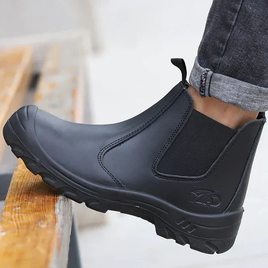 Men's black safety work boot being tested for grip on a wooden ledge