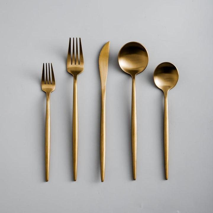 Full layout of a matte gold cutlery set including forks, knife, and spoons