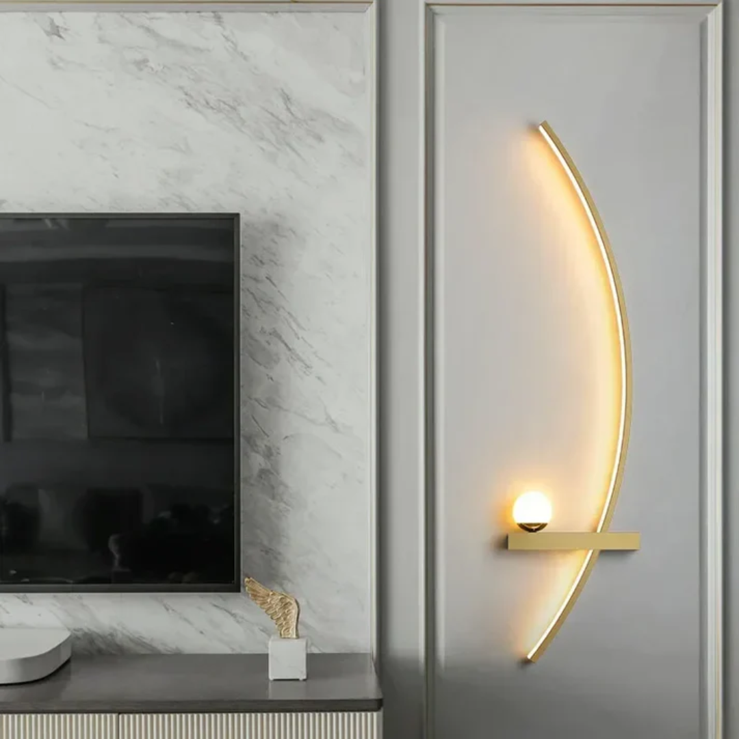 Gold LED wall lamp installed next to a television screen on a marble textured wall