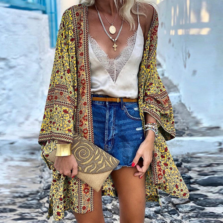 Woman wearing a yellow boho pattern cardigan with a camisole and denim shorts