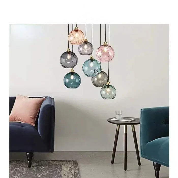 Cluster of colorful glass globe pendant lights hanging above a modern living room