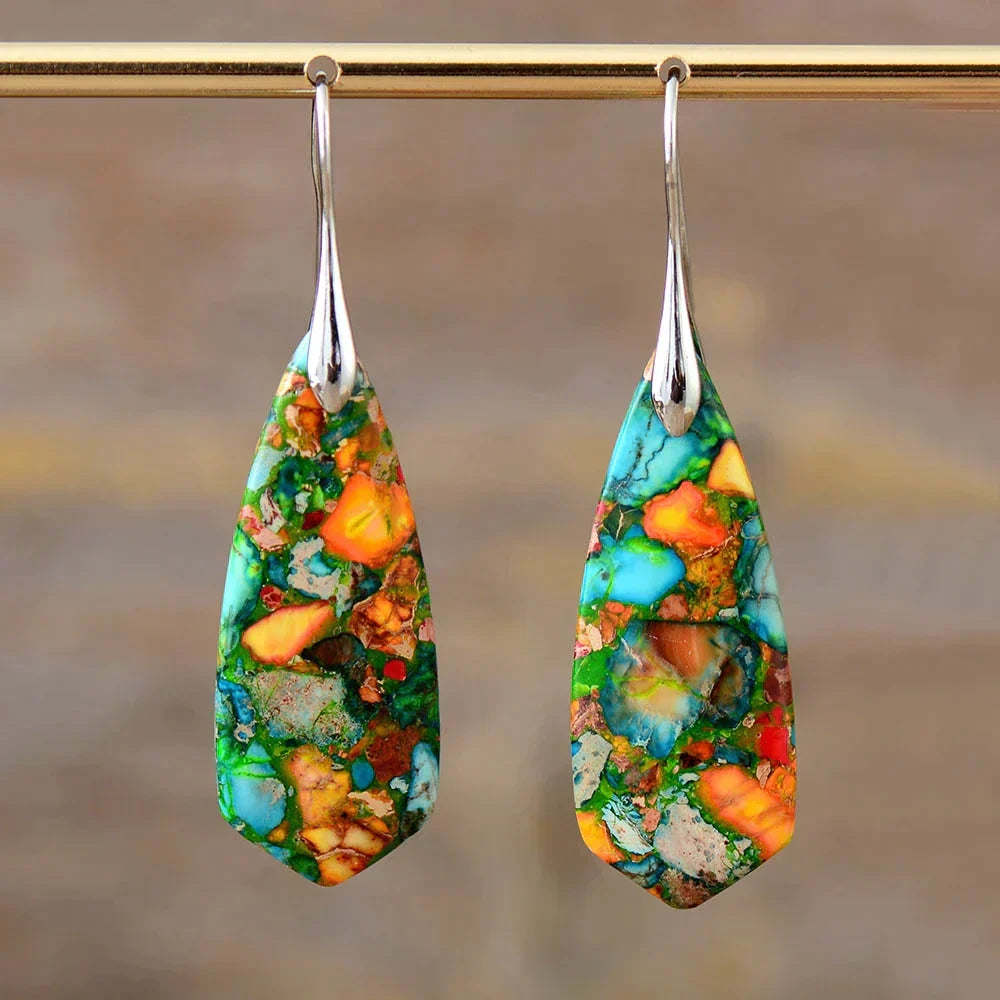 Pair of colorful jasper drop earrings hanging on a display bar