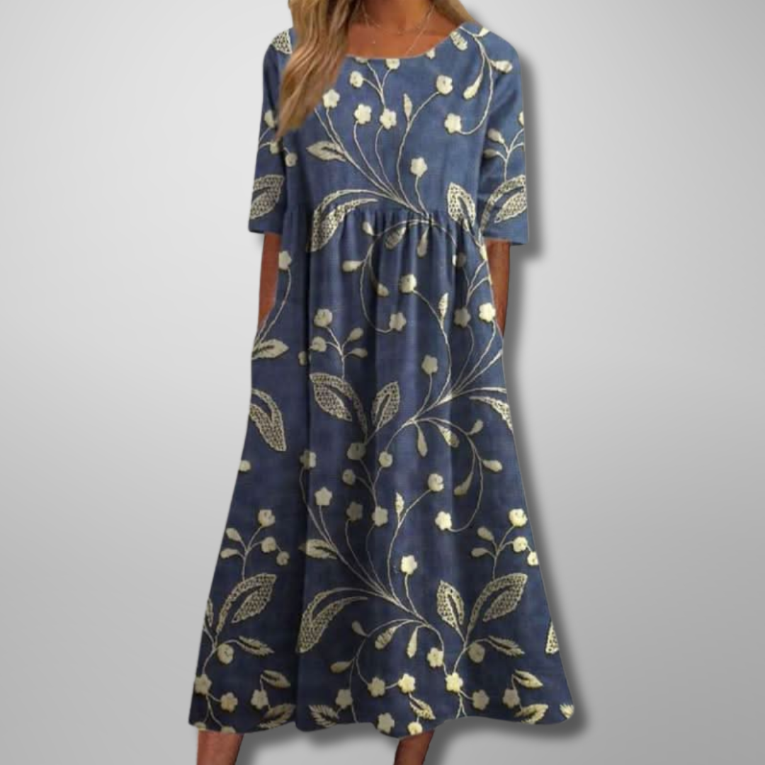 Model wearing dark blue short-sleeve floral midi dress with botanical pattern