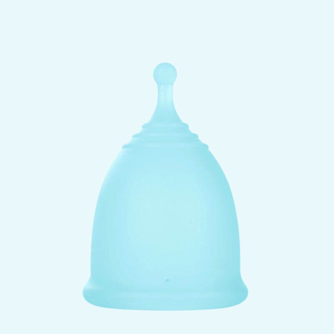 Medical silicone menstrual cup shown in a lifestyle flat lay arrangement