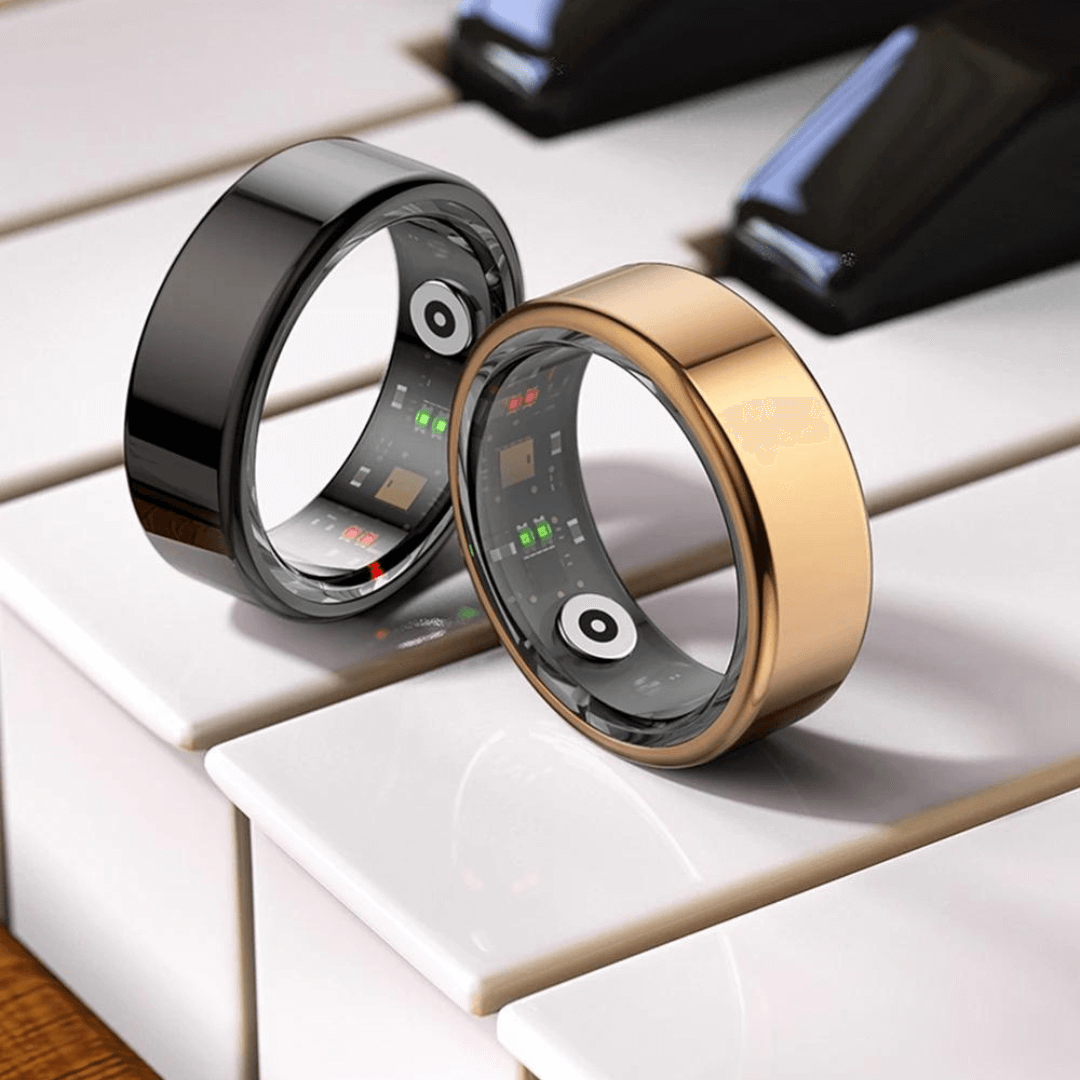 Black and gold titanium smart health tracker rings displayed elegantly on a piano keyboard.