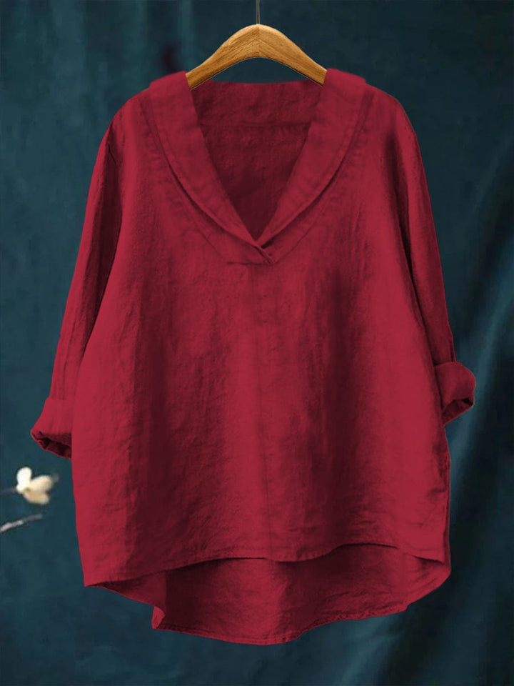 Red women's timeless blouse hanging on wooden hanger
