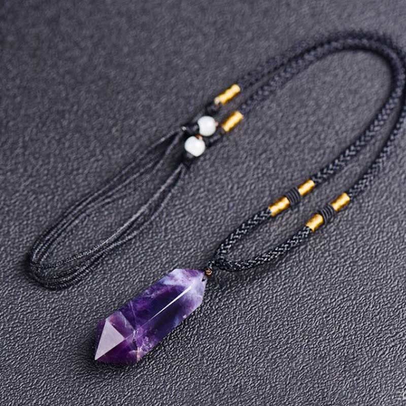 Full view of the adjustable gemstone crystal necklace resting on a textured surface