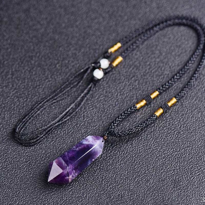 Full view of the adjustable gemstone crystal necklace resting on a textured surface