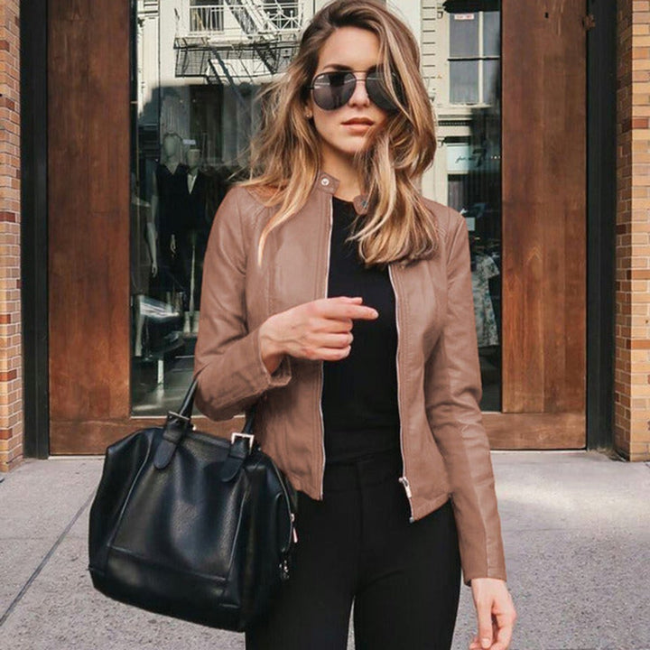 Slim-fit women's leather biker jacket showcasing detailed lapel hardware and zippered pockets