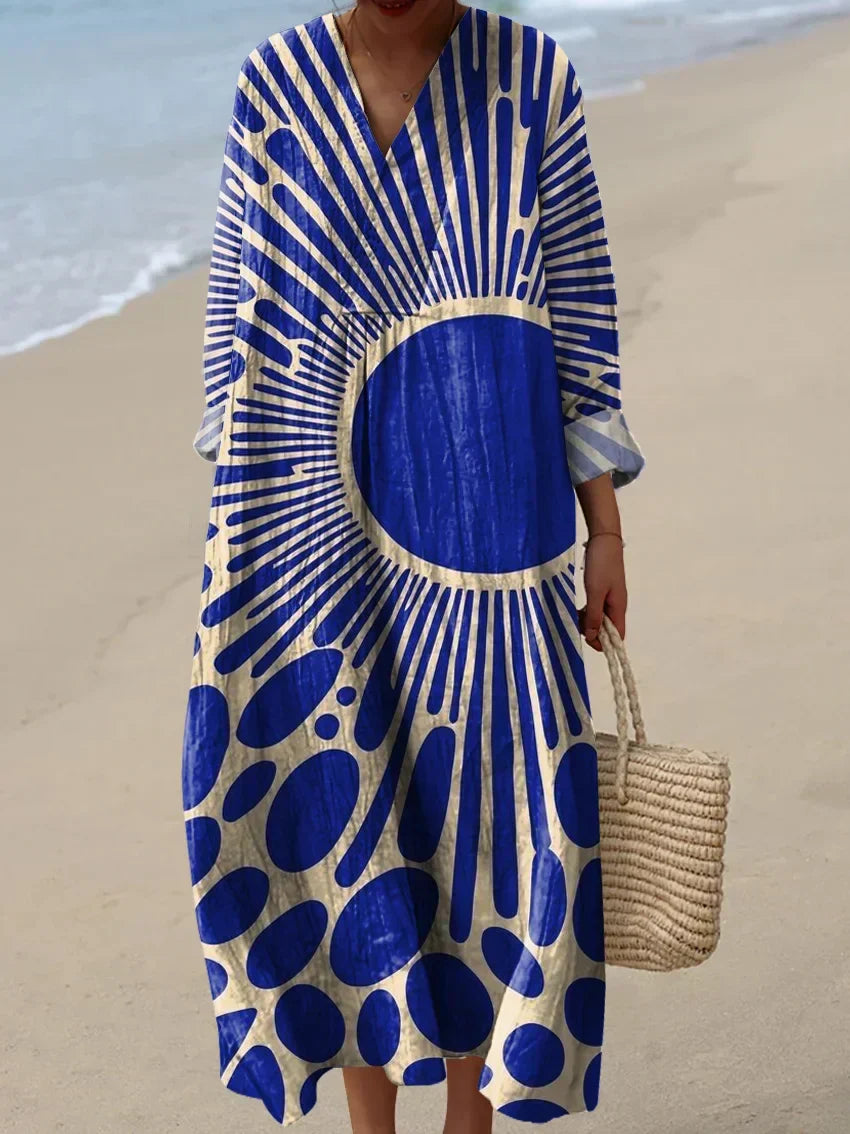 Woman wearing a blue printed sun dress on a sandy beach