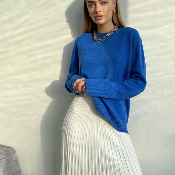 Woman wearing a vivid blue oversized knit jumper outdoors with sunlight