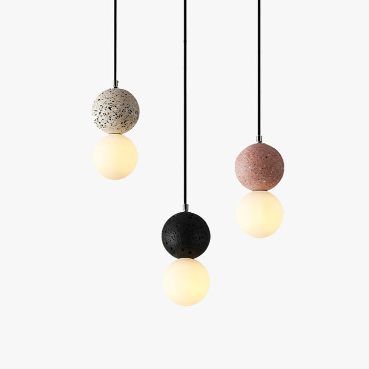 Three modern LED pendant lights hanging with different colored textured globes and glowing spheres