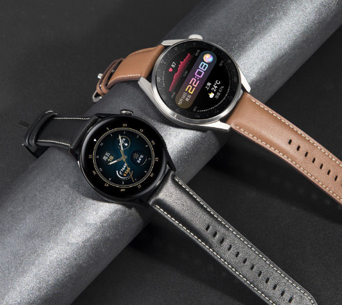 Black and silver smartwatches resting on a textured dark metallic surface