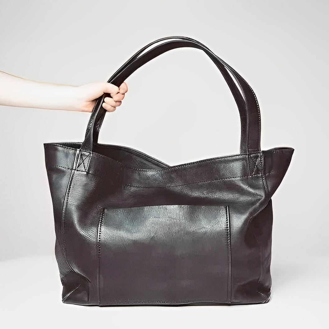 Women's vintage leather shoulder bag in black, showing the back and strap design