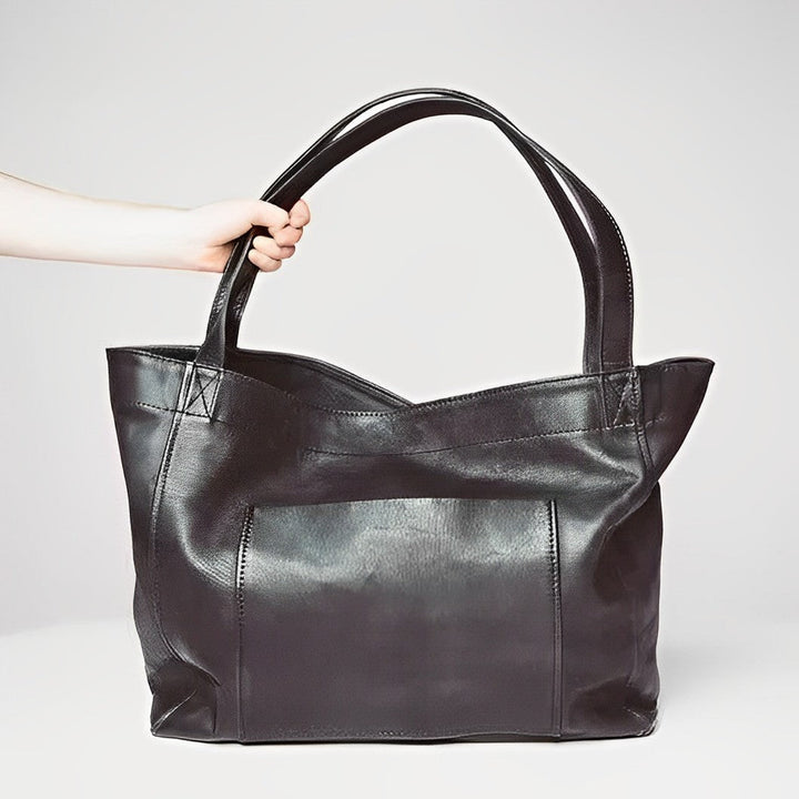 Women's vintage leather shoulder bag in black, showing the back and strap design