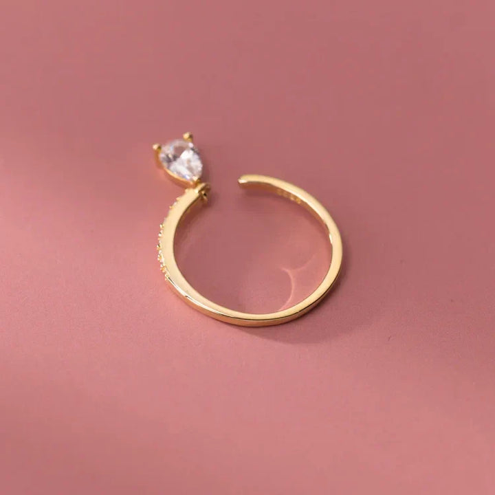 Close-up of a silver stackable teardrop ring featuring a brilliant gemstone