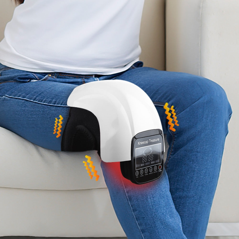 Woman sitting on a sofa using the electric heated knee massager on her leg