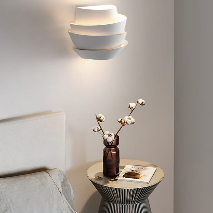 Sleek iron wall lamp casting dual light beams on a textured accent wall