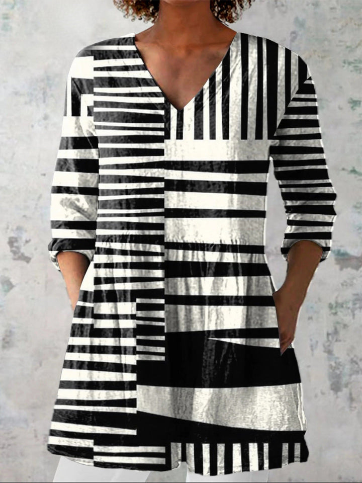 Woman wearing a black and white patterned long V-neck blouse from the front