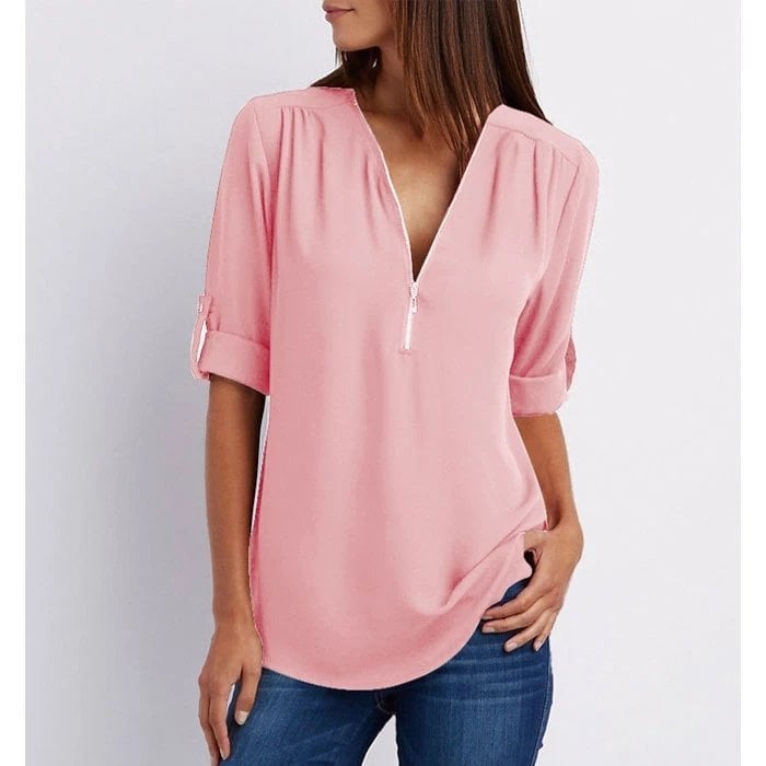 Woman wearing pink zip V-neck 3/4 sleeve blouse with blue jeans