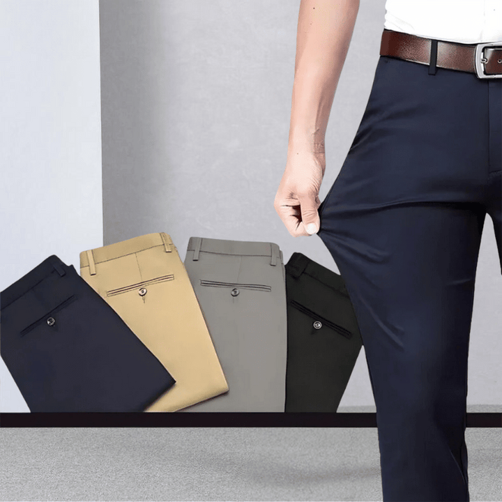 Man demonstrating the flexibility of dark blue stretch trousers with folded colour options displayed in the background.