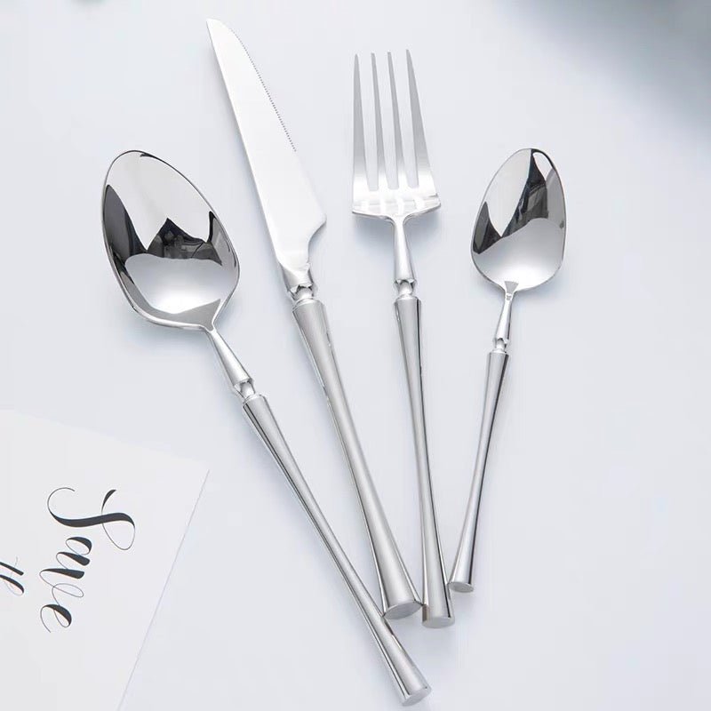 Elegant kitchen tableware and silver flatware set on dining table
