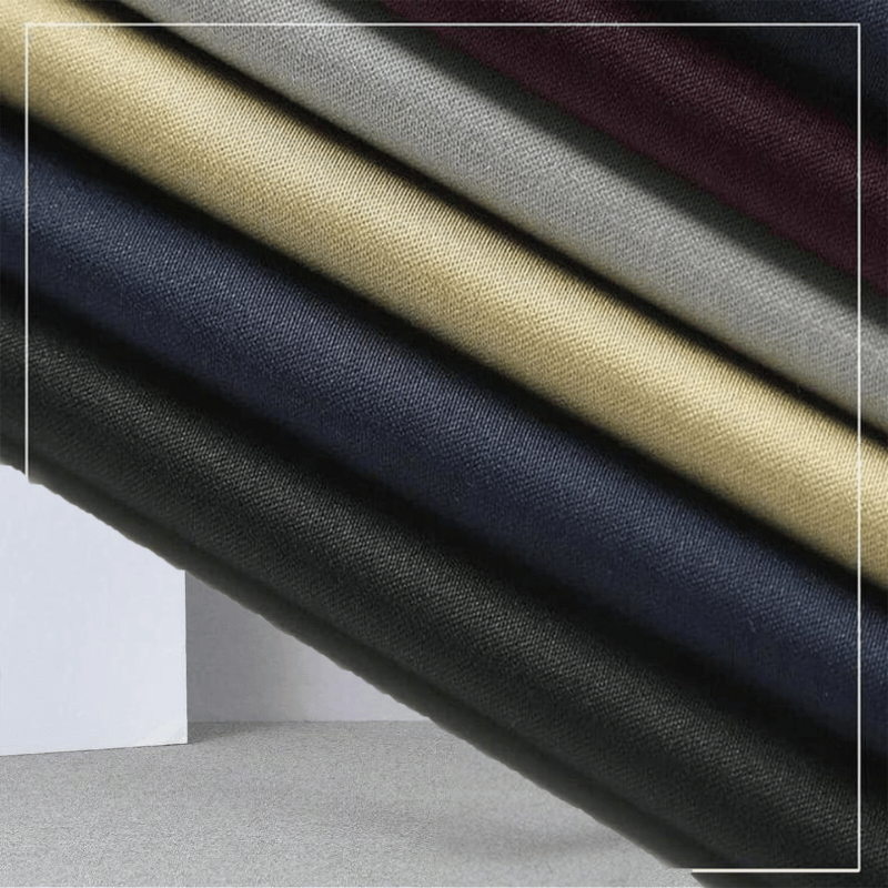 Close-up stack of fabric swatches showing the available colour options for the men's trousers.