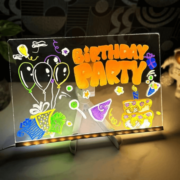 Child drawing a birthday party design on an illuminated LED board
