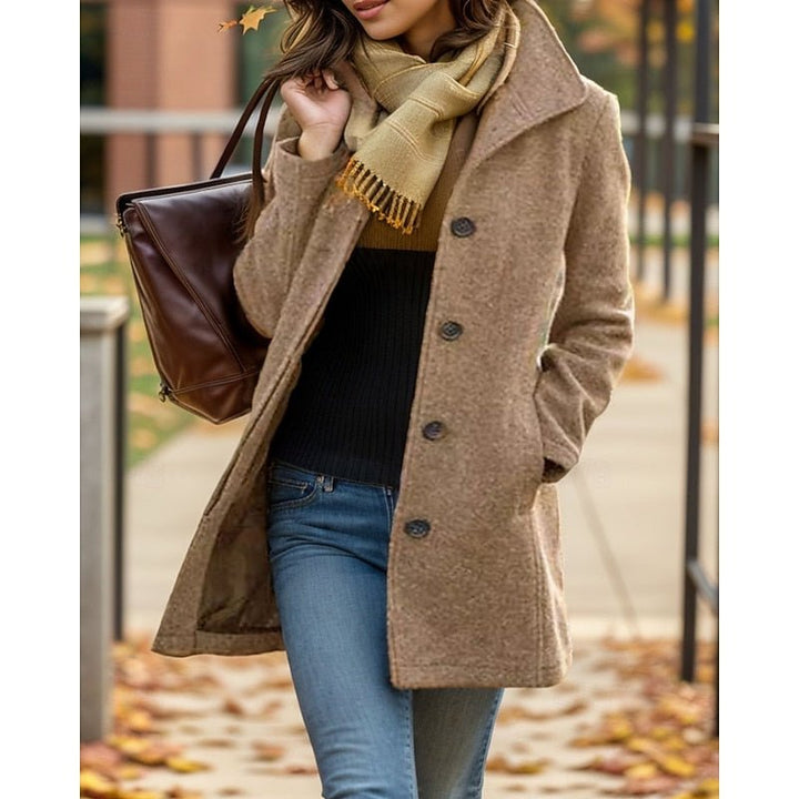 Close-up of a woman in a khaki turn-down collar trench coat with a brown handbag