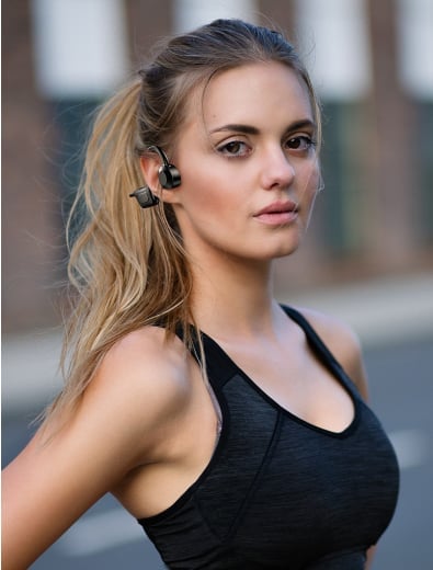 Pair of wireless earphones neatly coiled beside fitness gear essentials