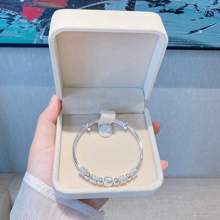 Adjustable silver bracelet for women shown worn on a wrist