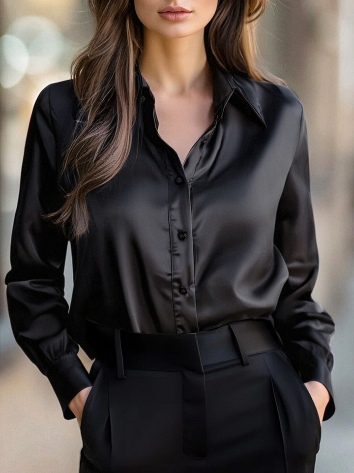 Front view of a woman wearing a black long sleeve button down blouse with lapels