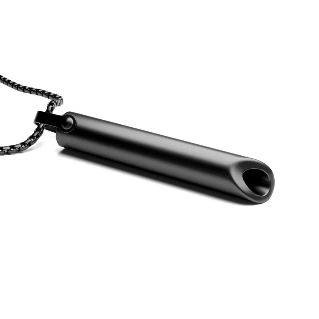Close up of the black rectangular breathing pendant resting beside its chain