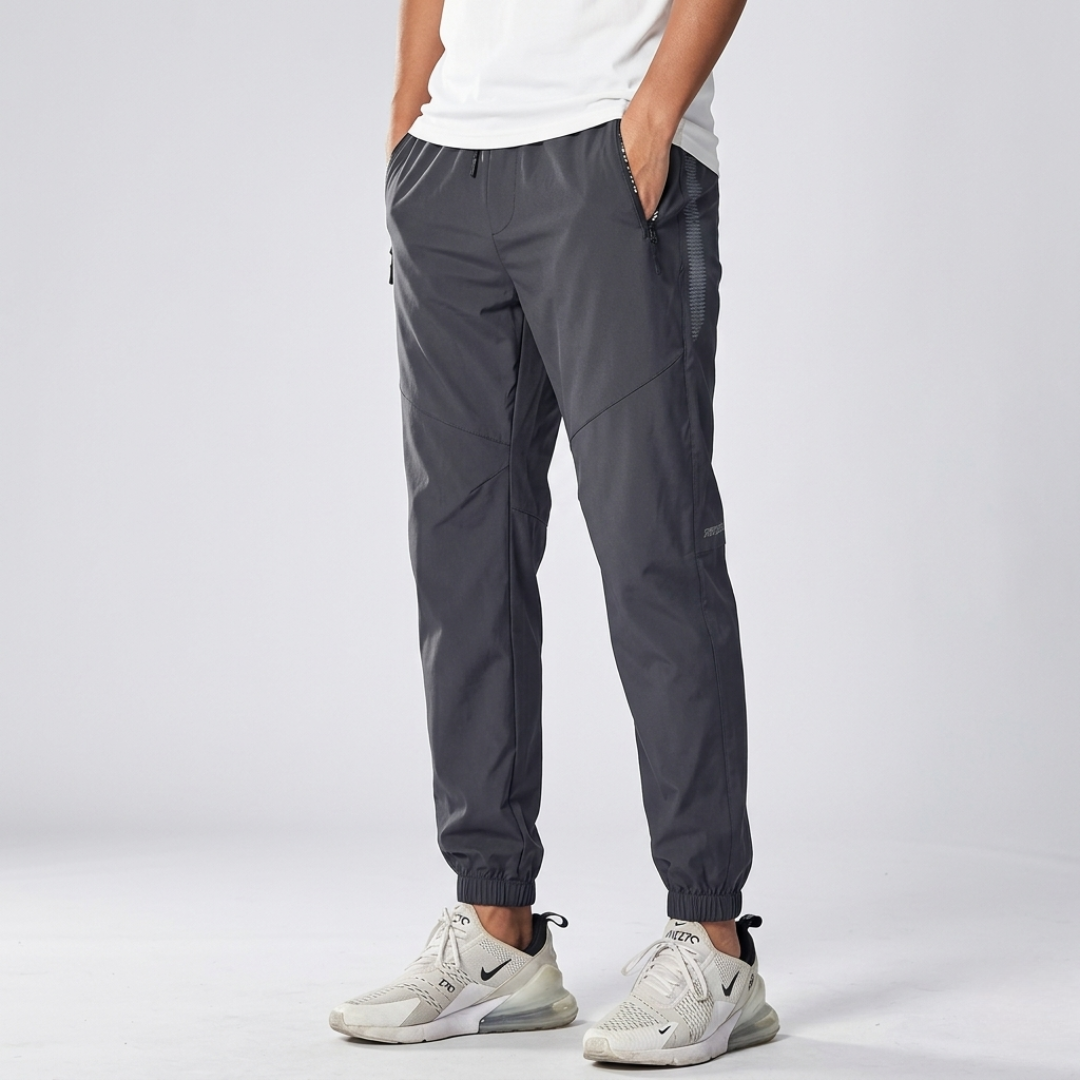 Studio shot of men's grey athletic training trousers with zip pockets