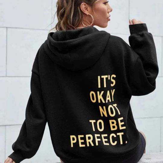 Back view of a woman wearing a black relaxed hoodie with yellow letter print