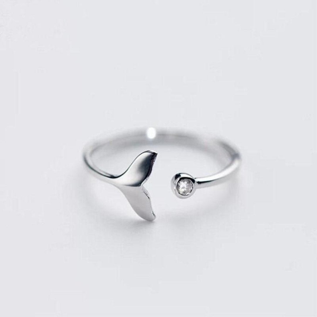 Adjustable silver dolphin tail ring with sparkling zirconia stone on white background