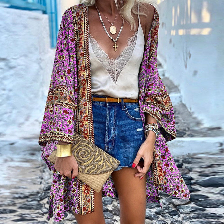 Woman wearing a pink boho pattern cardigan with layered necklaces
